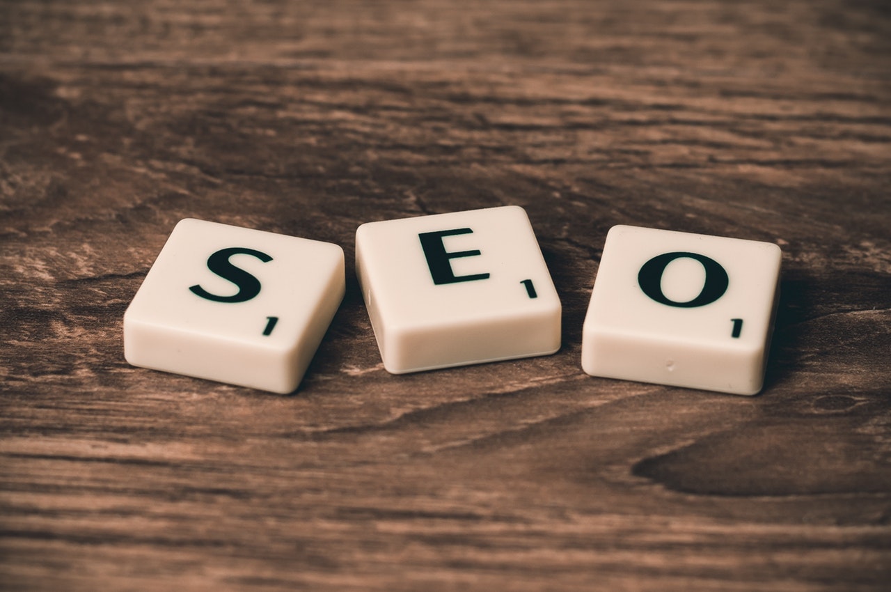 Scrabble cubes  on a wooden table with the acronym SEO spelt out in the middle